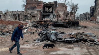 Un homme passe devant un char T72 détruit dans les ruines du centre de Marioupol. 